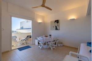 Coin repas intérieur avec table blanche et chaise pliante.